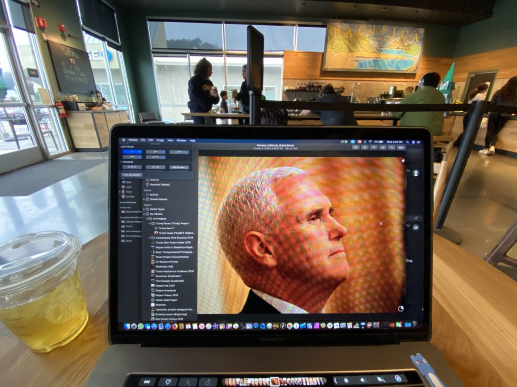 Vice President Pence shown on a laptop screen, the laptop sitting on a table in a coffee shop.
